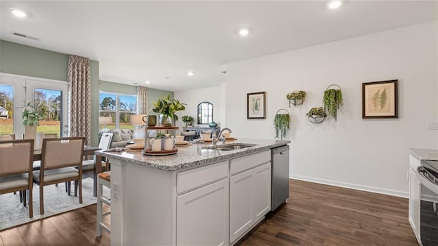 kitchen featuring light stone counters, dark wood-style flooring, a sink, visible vents, and dishwasher