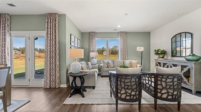 living room with visible vents, baseboards, and wood finished floors