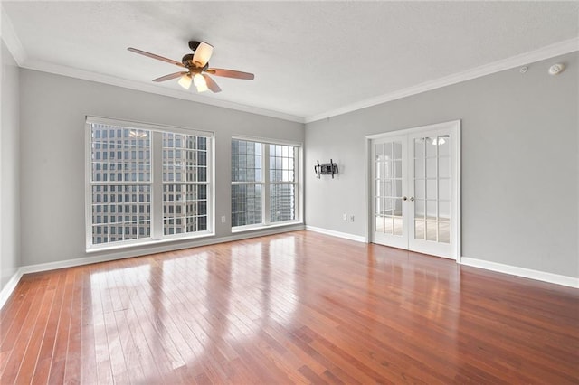 unfurnished room with baseboards, a ceiling fan, french doors, and hardwood / wood-style floors