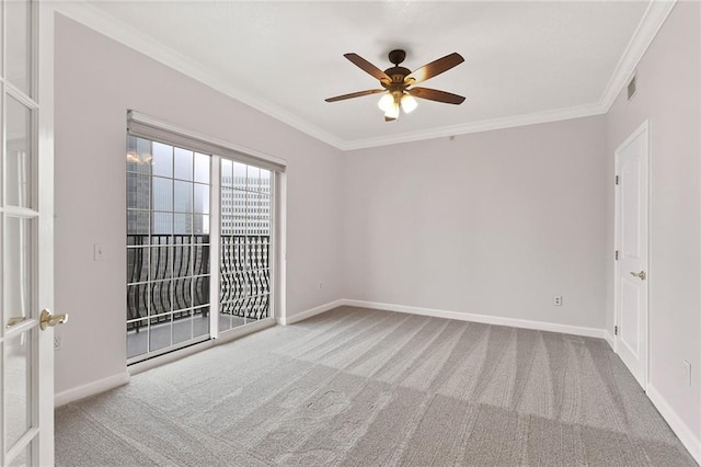 carpeted empty room with crown molding, baseboards, and ceiling fan