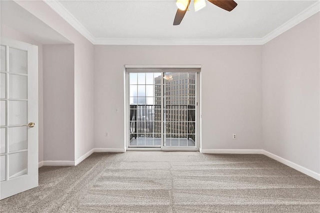 carpeted spare room with baseboards, a ceiling fan, and ornamental molding