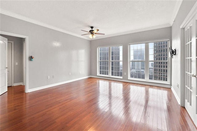 spare room featuring crown molding, a ceiling fan, baseboards, and hardwood / wood-style flooring