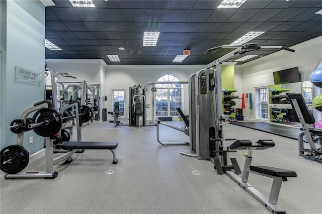exercise room with ornamental molding, visible vents, and a paneled ceiling