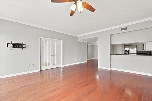 unfurnished living room with a ceiling fan, baseboards, wood finished floors, visible vents, and ornamental molding