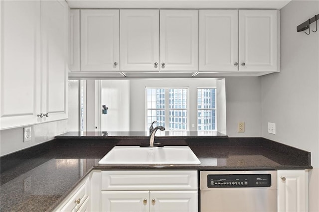 kitchen featuring dishwasher, a sink, white cabinets, a peninsula, and dark stone countertops