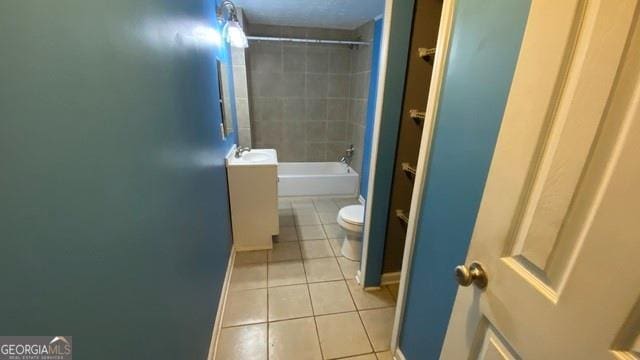 full bathroom featuring tile patterned floors, toilet,  shower combination, and baseboards