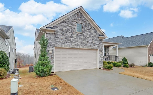 view of front of home featuring stone siding, central AC, a porch, and concrete driveway