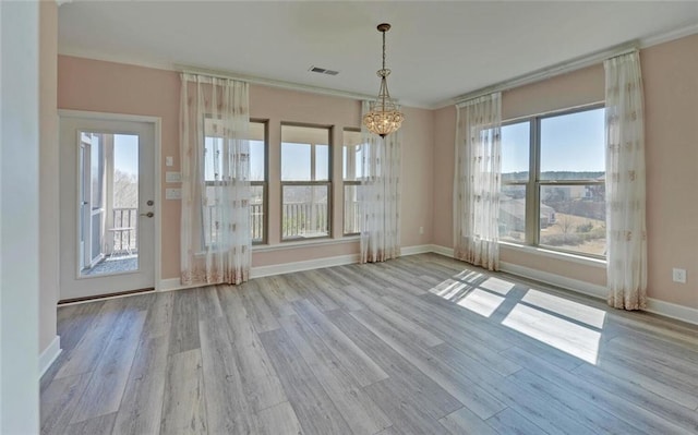 unfurnished dining area with a chandelier, visible vents, baseboards, and wood finished floors