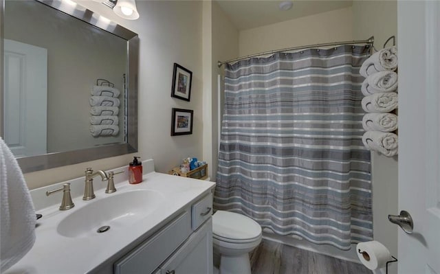 full bathroom with toilet, a shower with curtain, wood finished floors, and vanity