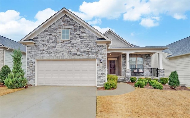 craftsman-style house featuring covered porch, concrete driveway, stone siding, and an attached garage