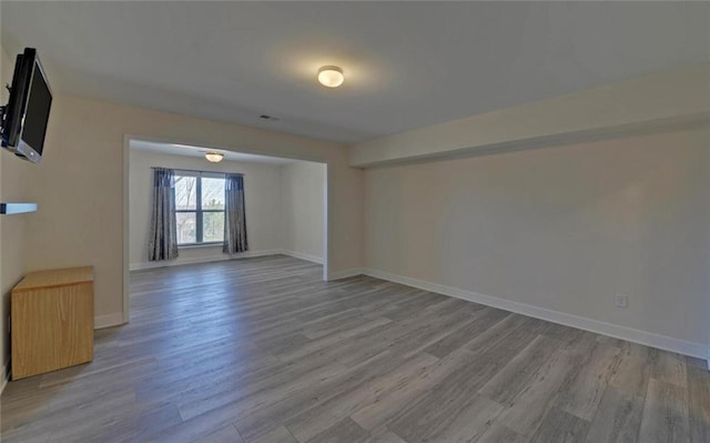 spare room with wood finished floors and baseboards