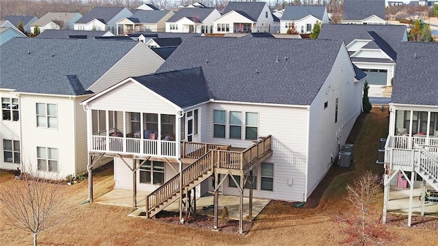 back of property featuring a residential view, a sunroom, a patio area, and stairway