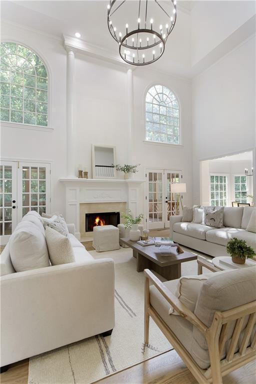 3795 Newport Bay Dr, Alpharetta, GA 30005 - living room with a towering ceiling, french doors, healthy amount of natural light, ornamental molding, and a lit fireplace