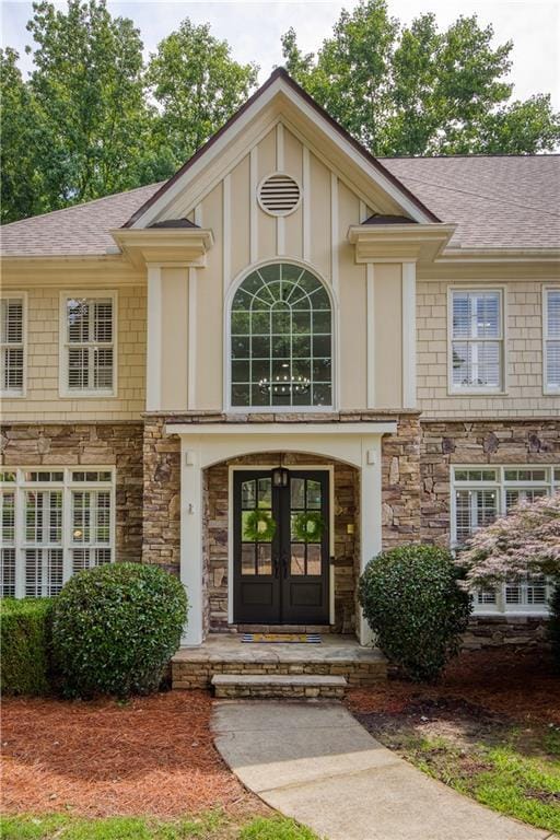 3795 Newport Bay Dr, Alpharetta, GA 30005 - entrance to property with stone siding, french doors, roof with shingles, and board and batten siding