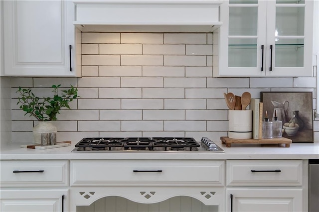 3795 Newport Bay Dr, Alpharetta, GA 30005 - kitchen featuring stainless steel gas cooktop, backsplash, light countertops, white cabinets, and glass insert cabinets