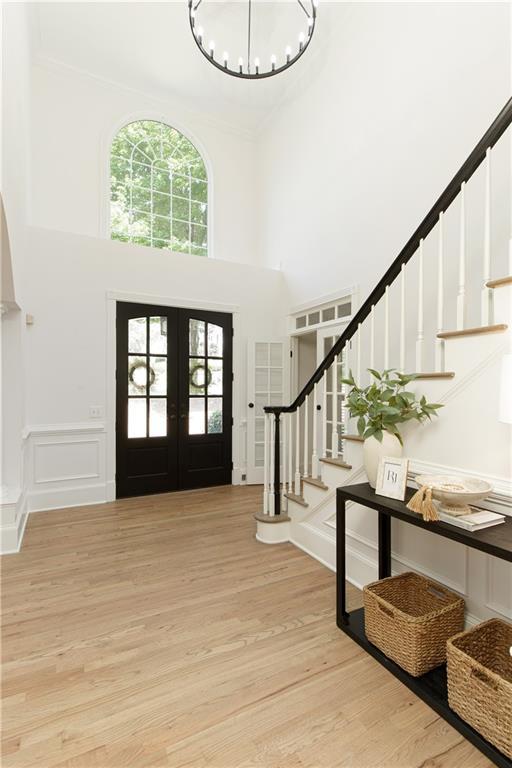 3795 Newport Bay Dr, Alpharetta, GA 30005 - entryway with stairs, french doors, a high ceiling, a chandelier, and light wood-style flooring
