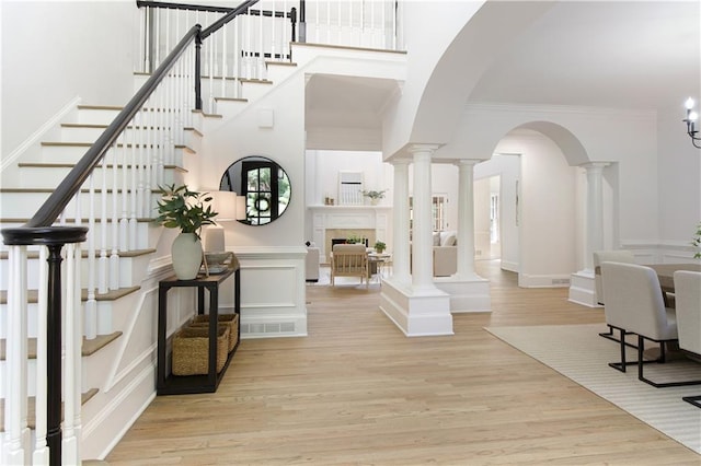 3795 Newport Bay Dr, Alpharetta, GA 30005 - entryway featuring wood finished floors, stairway, crown molding, a high ceiling, and ornate columns