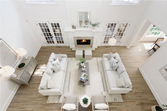 3795 Newport Bay Dr, Alpharetta, GA 30005 - living area with french doors, a towering ceiling, and wood finished floors