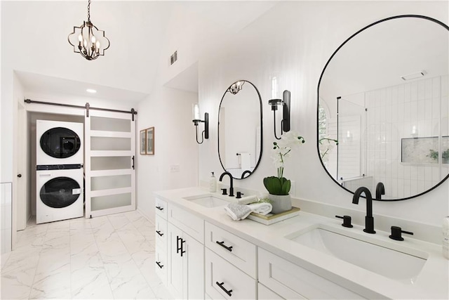 3795 Newport Bay Dr, Alpharetta, GA 30005 - full bath with stacked washing machine and dryer, double vanity, marble look tile flooring, a shower, and a chandelier
