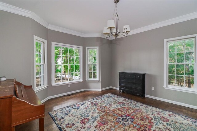 living area featuring dark hardwood / wood-style flooring, crown molding, and an inviting chandelier