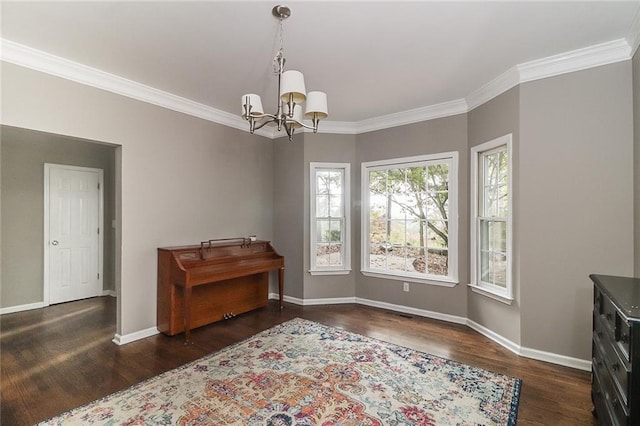 interior space with dark wood-type flooring, ornamental molding, and an inviting chandelier