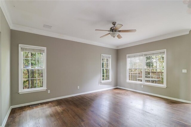 empty room featuring dark wood-type flooring, ceiling fan, and ornamental molding