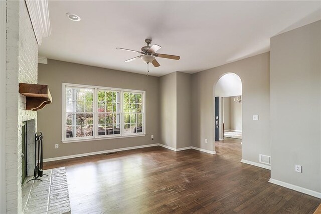 unfurnished living room featuring a brick fireplace, dark hardwood / wood-style flooring, and ceiling fan