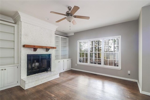 unfurnished living room with ceiling fan, a brick fireplace, and dark hardwood / wood-style floors