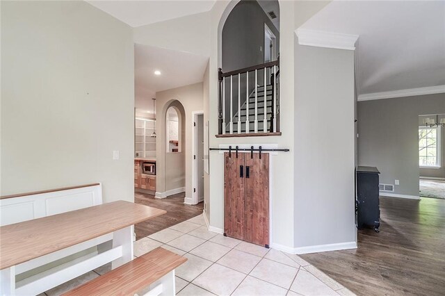 hall featuring light tile patterned floors and ornamental molding