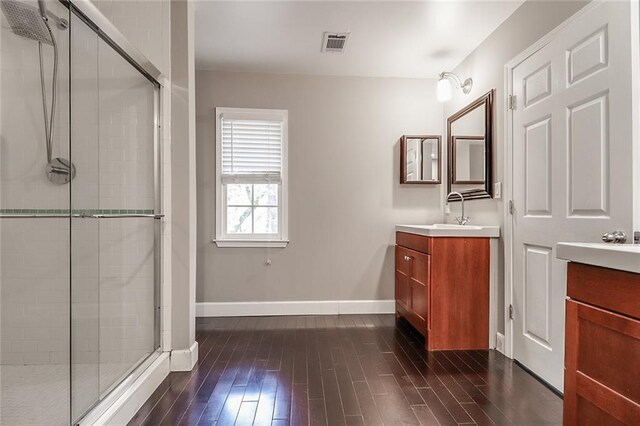 bathroom with walk in shower, vanity, and wood-type flooring