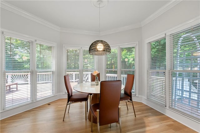 dining area featuring light hardwood / wood-style floors and crown molding