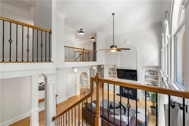 staircase with ornamental molding, hardwood / wood-style floors, and ceiling fan