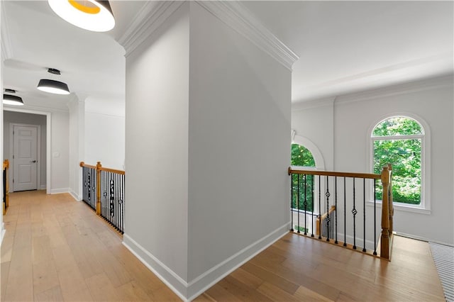 hallway with light hardwood / wood-style flooring and ornamental molding