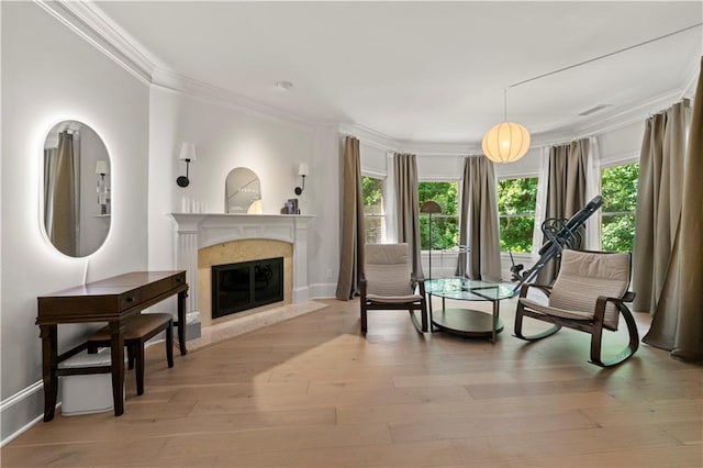 sitting room featuring crown molding, a high end fireplace, and light hardwood / wood-style floors