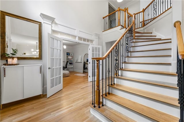 stairs with wood-type flooring and crown molding