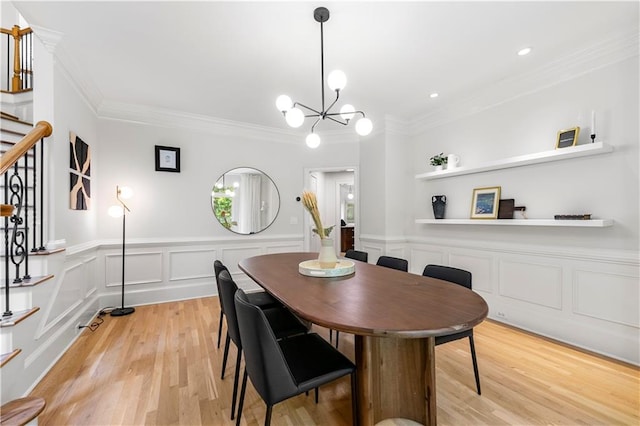 dining room with crown molding, light hardwood / wood-style flooring, and a notable chandelier