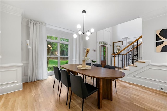 dining area with crown molding, light hardwood / wood-style flooring, and a chandelier