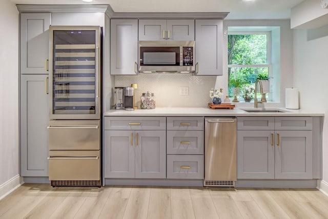 1343 Peachtree Battle Ave NW, Atlanta, GA 30327 - kitchen with gray cabinetry, a sink, stainless steel appliances, and light wood finished floors