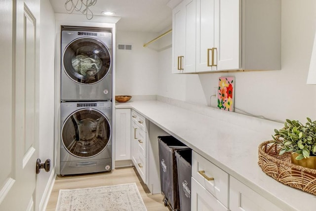 1343 Peachtree Battle Ave NW, Atlanta, GA 30327 - laundry area featuring stacked washer / dryer, cabinet space, light wood-style floors, and recessed lighting