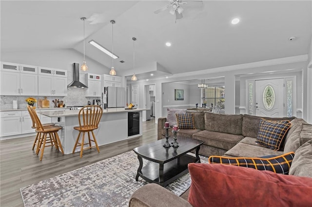 living room featuring ceiling fan, high vaulted ceiling, beverage cooler, and light hardwood / wood-style floors