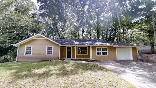 single story home with a garage, covered porch, driveway, and view of wooded area