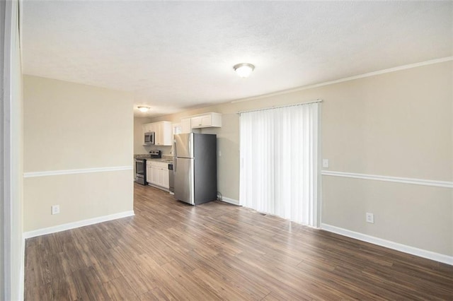 unfurnished living room with dark wood-type flooring and baseboards