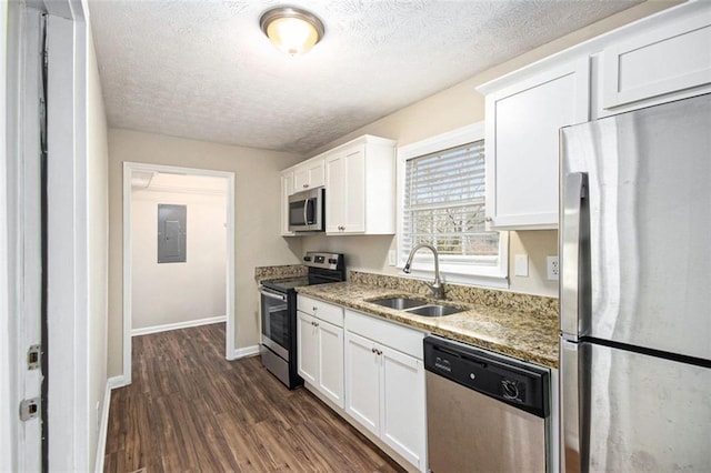 kitchen featuring dark wood-style flooring, a sink, white cabinets, appliances with stainless steel finishes, and electric panel