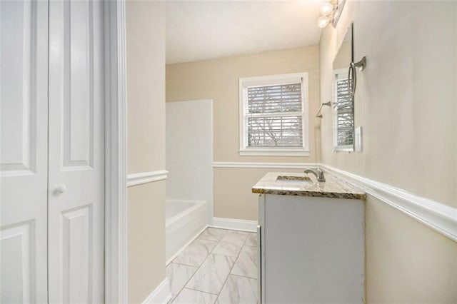 full bathroom featuring marble finish floor, vanity, and baseboards