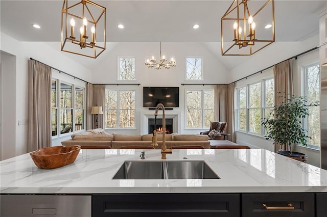 120 Nezhat Pl, Atlanta, GA 30350 - kitchen with a chandelier, dark cabinetry, open floor plan, an island with sink, and recessed lighting