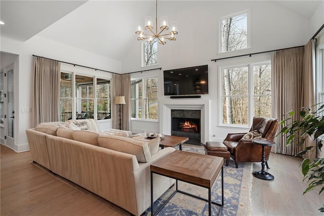 120 Nezhat Pl, Atlanta, GA 30350 - living area featuring a tiled fireplace, wood finished floors, high vaulted ceiling, plenty of natural light, and a chandelier