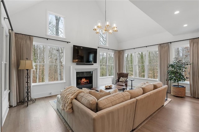 120 Nezhat Pl, Atlanta, GA 30350 - living room featuring high vaulted ceiling, a warm lit fireplace, wood finished floors, healthy amount of natural light, and recessed lighting