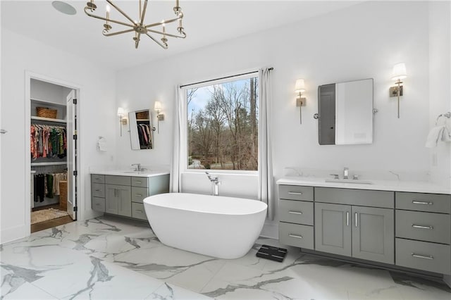 120 Nezhat Pl, Atlanta, GA 30350 - bathroom with a chandelier, marble finish floors, two vanities, a freestanding tub, and a spacious closet