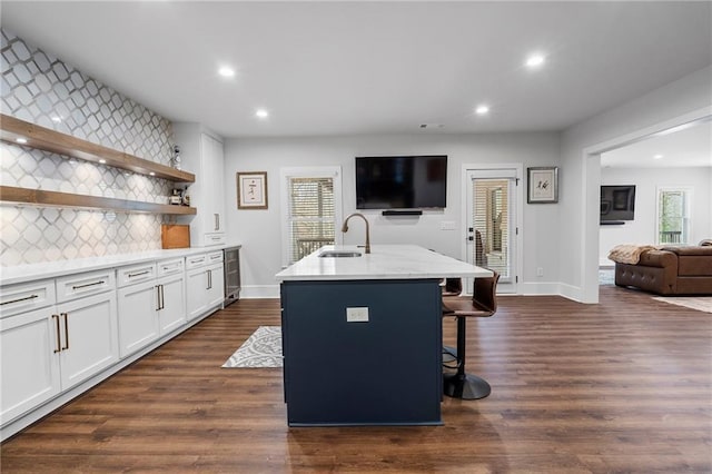 120 Nezhat Pl, Atlanta, GA 30350 - kitchen with a sink, an island with sink, white cabinets, decorative backsplash, and a breakfast bar