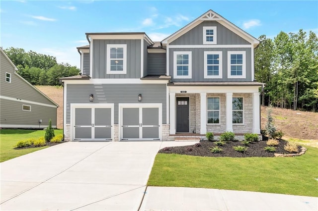 craftsman-style house with a front lawn, driveway, stone siding, board and batten siding, and a garage